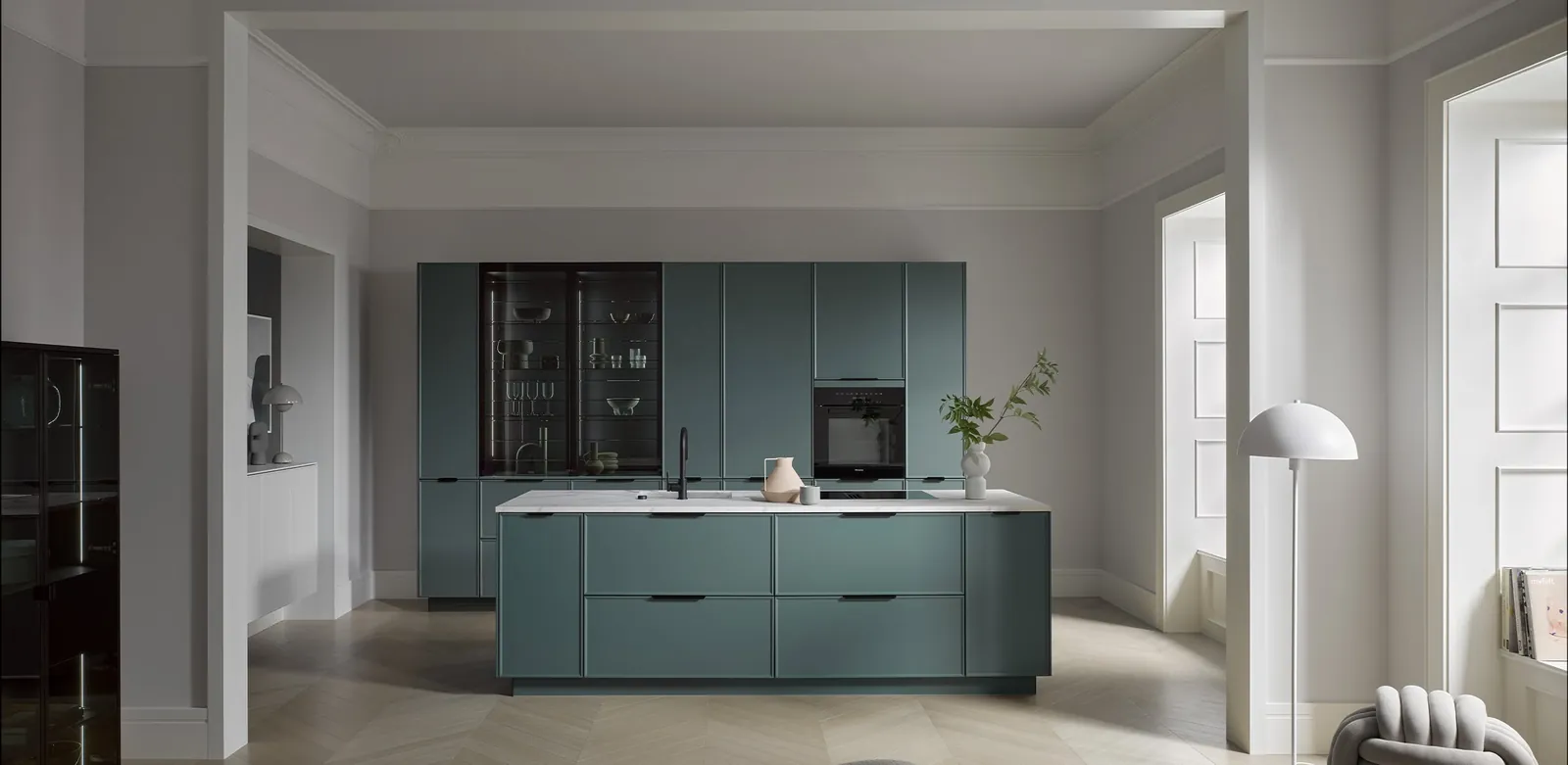 A sage green handleless kitchen with timber floor